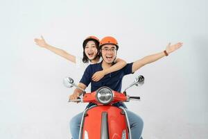 A couple wearing helmets and riding a motorbike photo