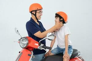 padre y hijo vistiendo cascos y montando motos foto