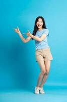 Portrait of smiling asian woman posing on blue background photo