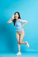 Portrait of smiling asian woman posing on blue background photo