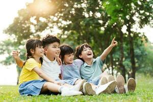 grupo de linda asiático niños teniendo divertido en el parque foto