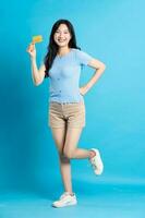lleno cuerpo imagen de hermosa asiático niña posando en azul antecedentes foto