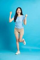 full body image of beautiful asian girl posing on blue background photo