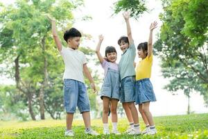 group of cute asian kids having fun in the park photo