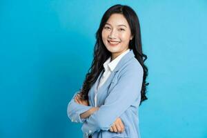 portrait of asian business woman posing on blue background photo