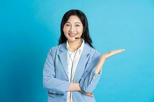 retrato de asiático negocio mujer posando en azul antecedentes foto