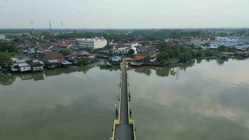 un aéreo ver de un amarillo peatonal puente cruzar Sungai Kurau video