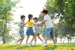 grupo imagen de asiático niños teniendo divertido en el parque foto