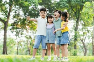 group of cute asian kids having fun in the park photo