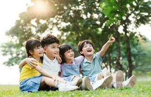 grupo de linda asiático niños teniendo divertido en el parque foto