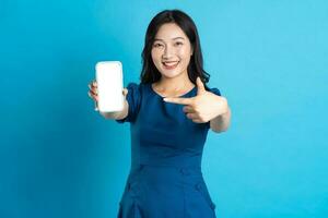 Portrait of beautiful woman in blue dress, isolated on blue background photo