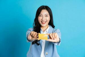 portrait of young asian businesswoman posing on blue background photo