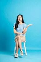 Portrait of smiling asian woman posing on blue background photo