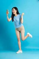 full body image of beautiful asian girl posing on blue background photo
