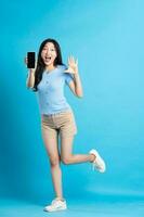 full body image of beautiful asian girl posing on blue background photo