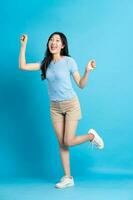 full body image of beautiful asian girl posing on blue background photo