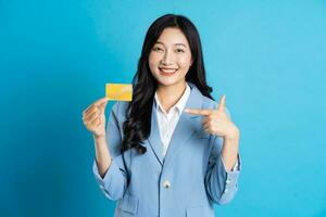 retrato de joven asiático mujer de negocios posando en azul antecedentes foto