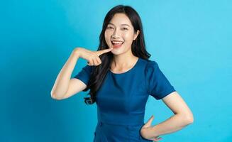 Portrait of beautiful woman in blue dress, isolated on blue background photo