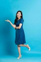 Portrait of beautiful woman in blue dress, isolated on blue background photo