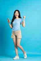 full body image of beautiful asian girl posing on blue background photo