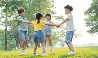 grupo imagen de asiático niños teniendo divertido en el parque foto