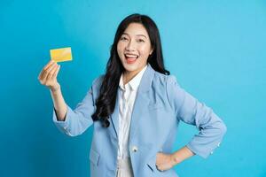 retrato de joven asiático mujer de negocios posando en azul antecedentes foto