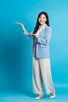 Asian young businesswoman portrait on blue background photo