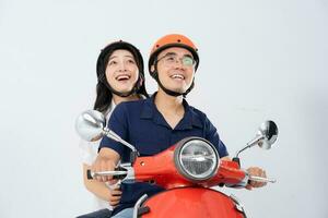 A couple wearing helmets and riding a motorbike photo