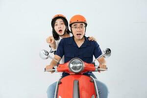 A couple wearing helmets and riding a motorbike photo