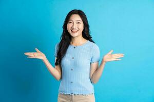 Portrait of a happy smiling asian girl posing on a blue background photo