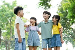 grupo de linda asiático niños teniendo divertido en el parque foto