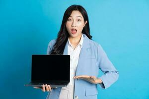 Asian business woman portrait using laptop on blue background photo
