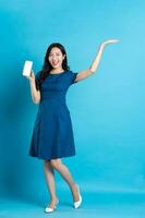 Portrait of beautiful woman in blue dress, isolated on blue background photo