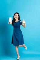 Portrait of beautiful woman in blue dress, isolated on blue background photo