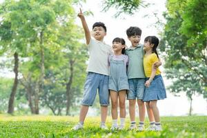 grupo de linda asiático niños teniendo divertido en el parque foto