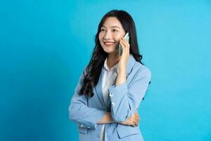 retrato de joven asiático mujer de negocios posando en azul antecedentes foto