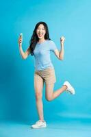 Portrait of smiling asian woman posing on blue background photo