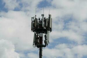 A closeup of a television antenna and wi-fi transmitter with cloudy sky photo