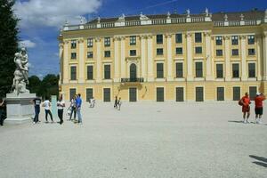 WIEN,AUSTRIA-08.15.2011 A group of people walking in front of a Schonbrunn Palace photo