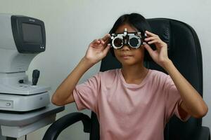 Child eye test in optical store, kid eye check in clinic photo