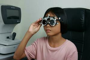 Child eye test in optical store, kid eye check in clinic photo