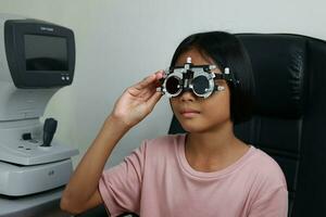 Child eye test in optical store, kid eye check in clinic photo