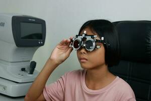 Child eye test in optical store, kid eye check in clinic photo