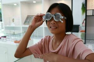 Eye care, Child wearing glasses in the optical store, kid eye test, children eye check, eye exam, child eye test, photo