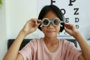 ojo cuidado, niño vistiendo lentes en el óptico almacenar, niño ojo prueba, niños ojo controlar, ojo examen, niño ojo prueba, foto