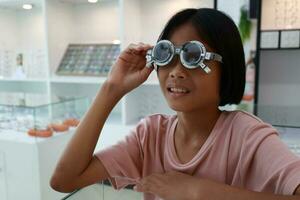 ojo cuidado, niño vistiendo lentes en el óptico almacenar, niño ojo prueba, niños ojo controlar, ojo examen, niño ojo prueba, foto