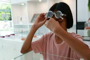 Eye care, Child wearing glasses in the optical store, kid eye test, children eye check, eye exam, child eye test, photo