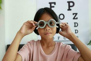 ojo cuidado, niño vistiendo lentes en el óptico almacenar, niño ojo prueba, niños ojo controlar, ojo examen, niño ojo prueba, foto