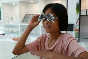 Eye care, Child wearing glasses in the optical store, kid eye test, children eye check, eye exam, child eye test, photo