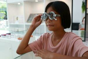 Eye care, Child wearing glasses in the optical store, kid eye test, children eye check, eye exam, child eye test, photo